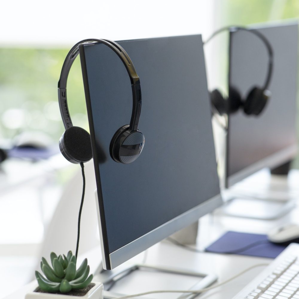 Computer monitor with empty space for your design and VOIP headset on desk at modern office